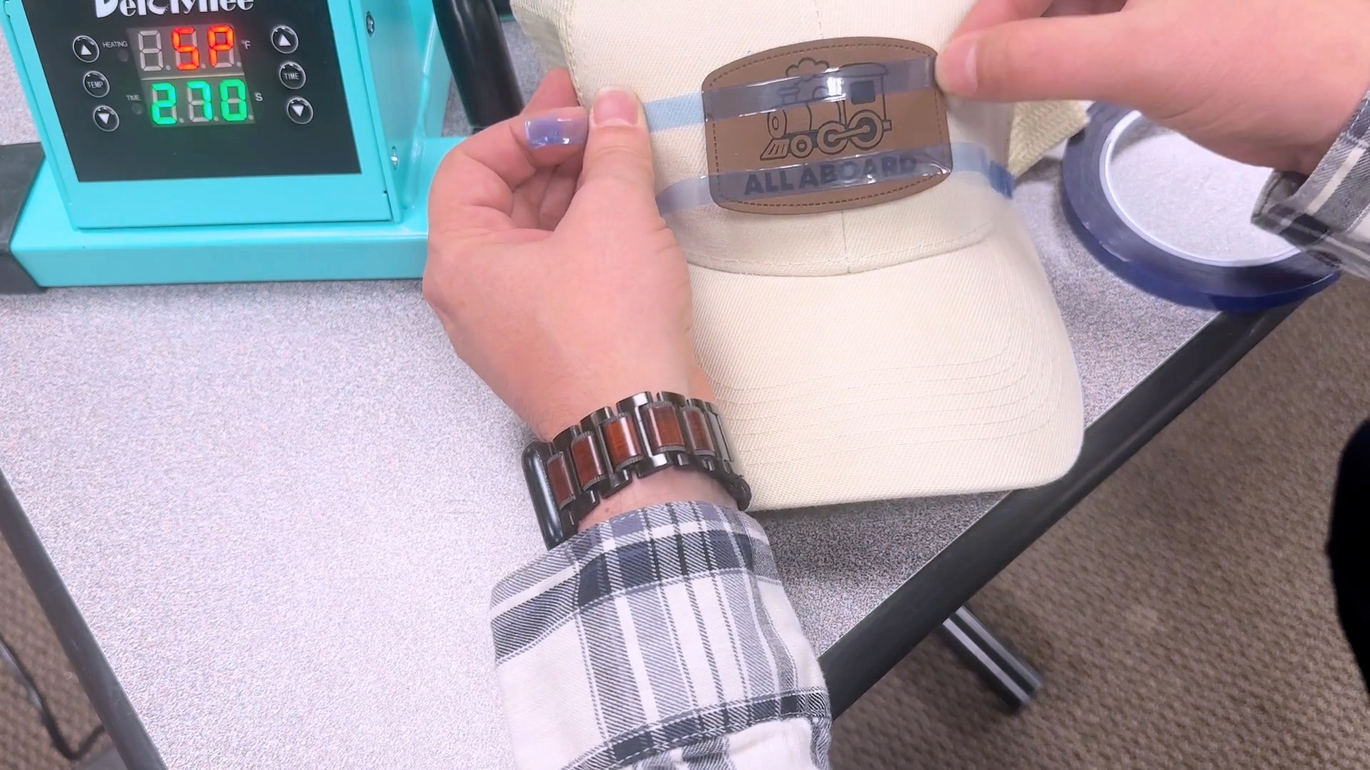 Menempelkan selotip pada tambalan topi