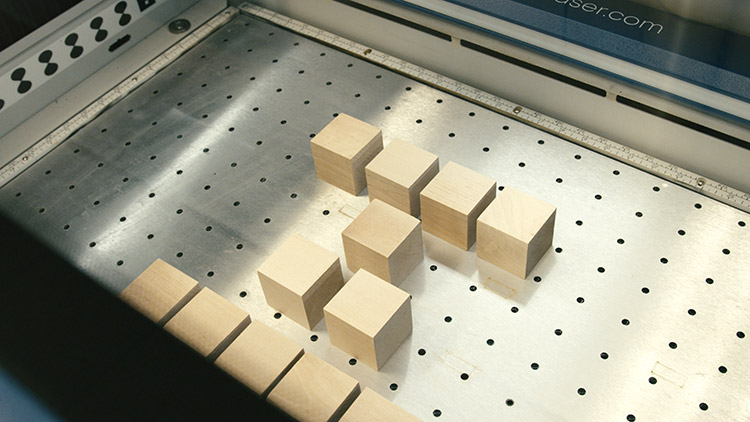 Wooden baby blocks layed out inside the laser engraver