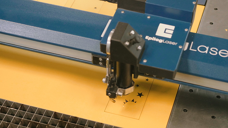 Memotong cardstock kertas kuning dengan laser