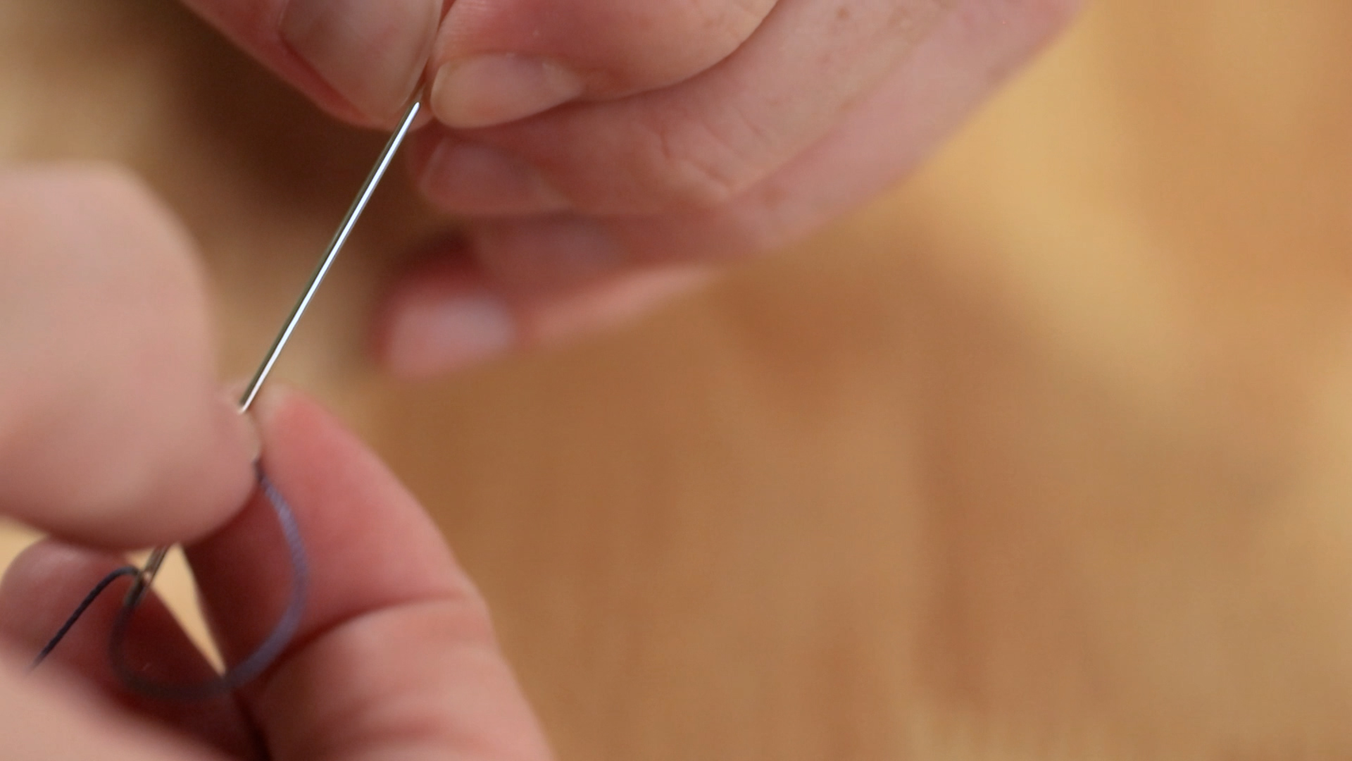 Tying thread to sewing needle