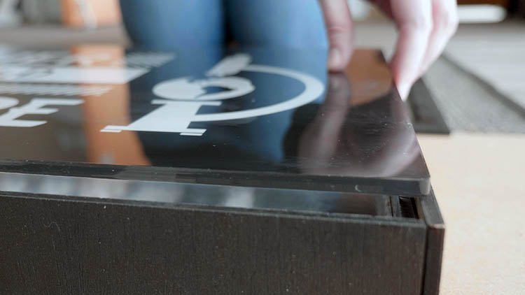 Close-up of inserting the acrylic into the front of the sign box.