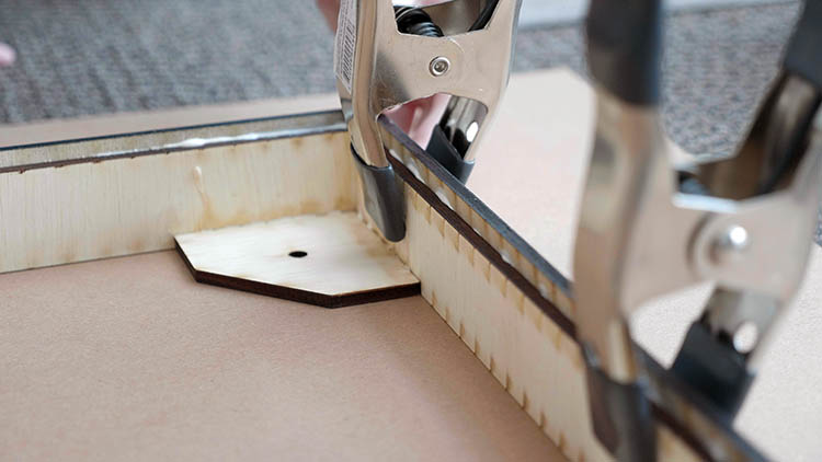 More clamps securing a laser-cut plywood glue-up.