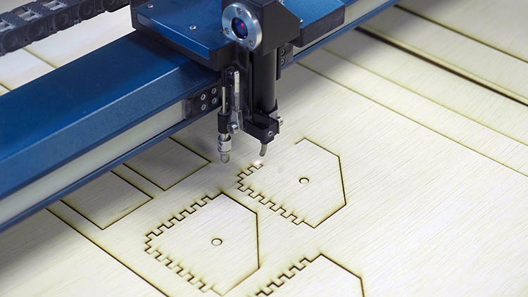 Máquina Epilog Laser cortando uniones dentadas.