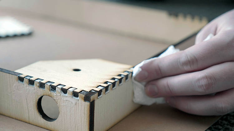 Gluing together laser cut plywood finger joints.