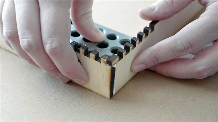 Gluing together laser cut plywood components.