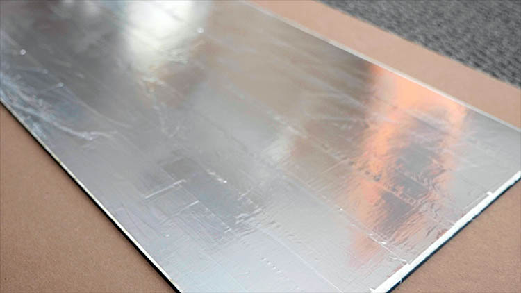O painel posterior de contraplacado revestido a fita adesiva de alumínio.