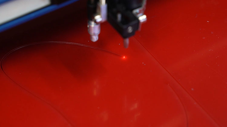 cutting red acrylic layer