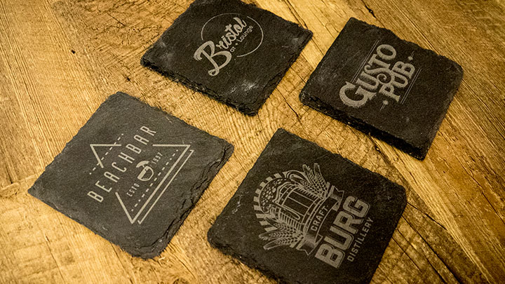 custom laser engraved slate coasters with wood background