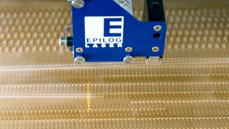 Tie being cut inside an Epilog Laser machine.
