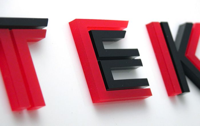 Nærbilde av bokstaver i Intutek-akrylskilt